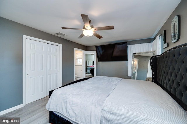 bedroom featuring light wood finished floors, visible vents, baseboards, a closet, and a ceiling fan