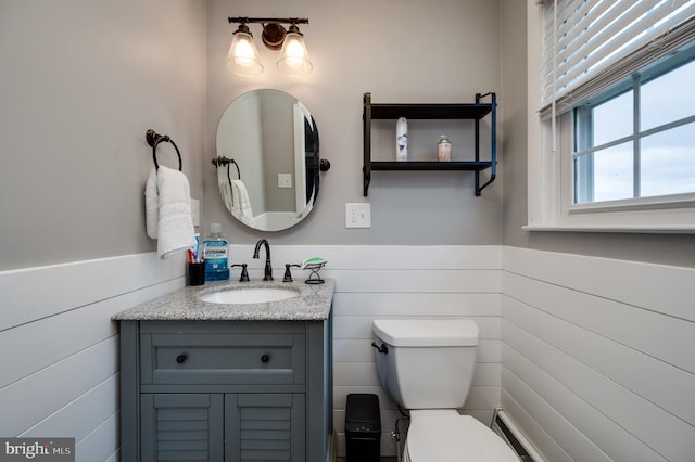 bathroom with vanity, wainscoting, and toilet