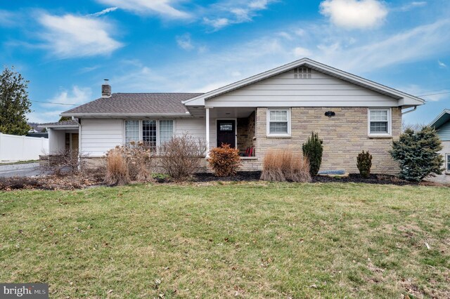 ranch-style home featuring stone siding, fence, a front yard, a shingled roof, and a chimney