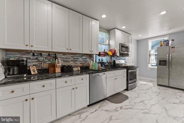 kitchen with marble finish floor, backsplash, white cabinets, and stainless steel appliances