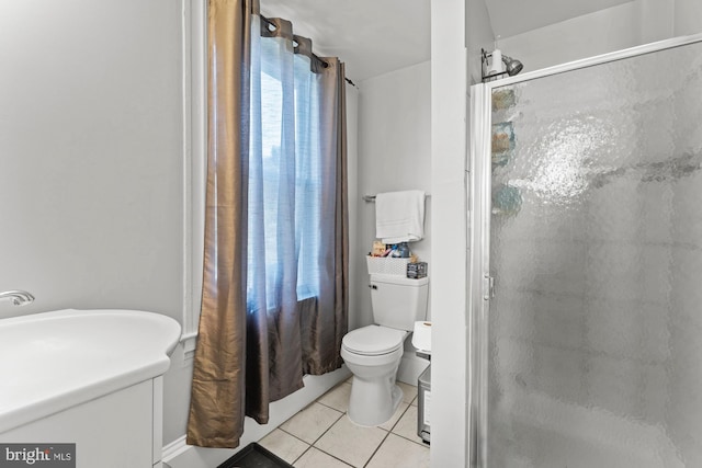 bathroom with toilet, tile patterned flooring, and a stall shower