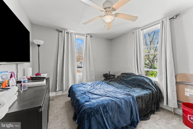 bedroom featuring light colored carpet and a ceiling fan