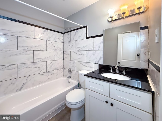 bathroom featuring washtub / shower combination, toilet, and vanity