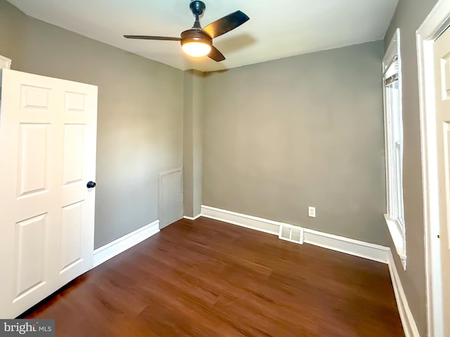 unfurnished room featuring a ceiling fan, dark wood-style floors, and baseboards