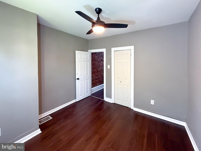 unfurnished bedroom featuring wood finished floors, baseboards, and a closet