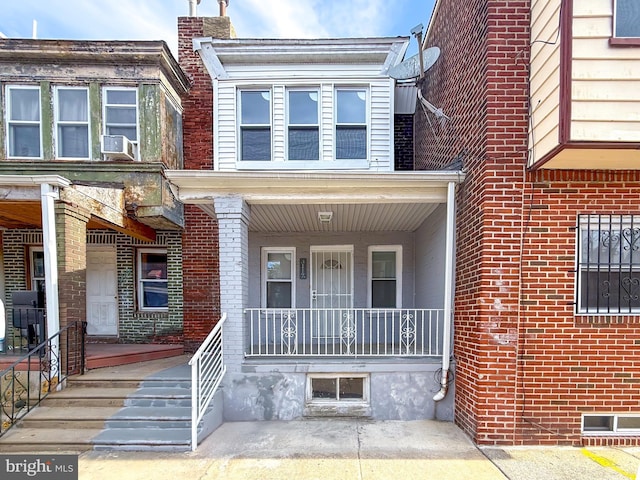 view of front of home with covered porch and brick siding