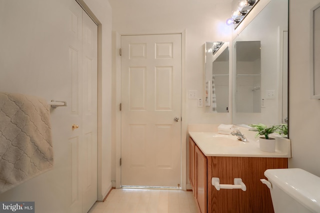bathroom featuring vanity, tile patterned floors, and toilet
