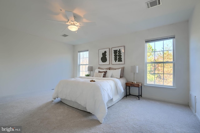 bedroom with visible vents, multiple windows, and light colored carpet