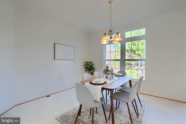 dining area with baseboards and an inviting chandelier