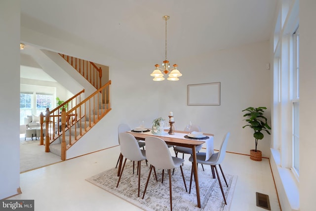 dining room with stairway, visible vents, and a chandelier