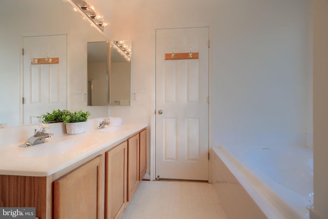 bathroom featuring a sink, a tub to relax in, and double vanity