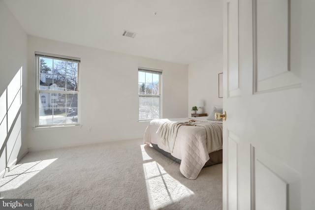 bedroom with visible vents and light colored carpet