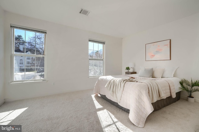 carpeted bedroom featuring visible vents