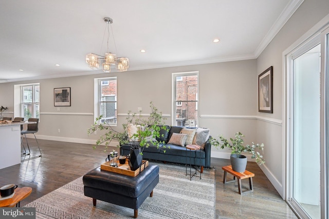 living area featuring an inviting chandelier, wood finished floors, baseboards, ornamental molding, and recessed lighting