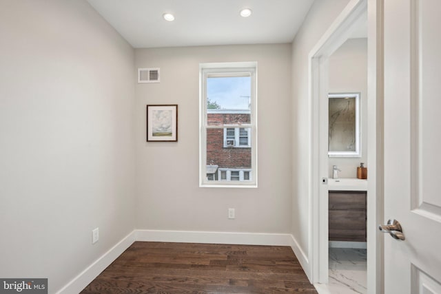interior space featuring a sink, visible vents, dark wood-style flooring, baseboards, and recessed lighting