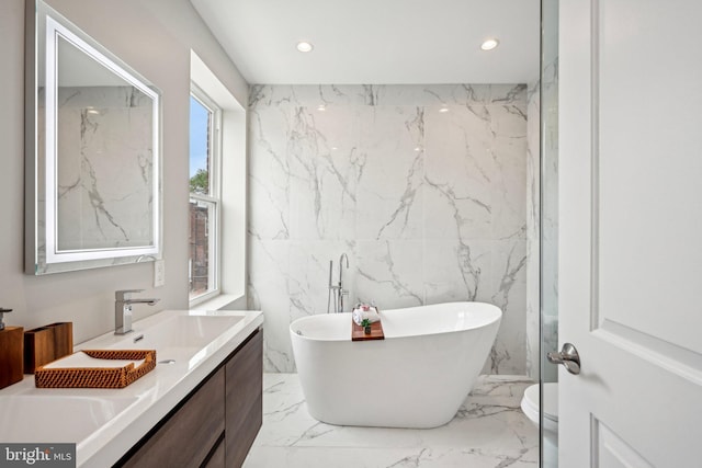 full bath featuring vanity, marble finish floor, a soaking tub, and recessed lighting