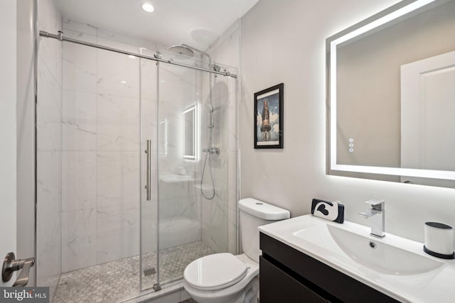 full bath featuring vanity, toilet, and a marble finish shower