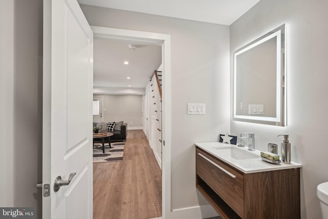bathroom featuring recessed lighting, toilet, baseboards, vanity, and wood finished floors
