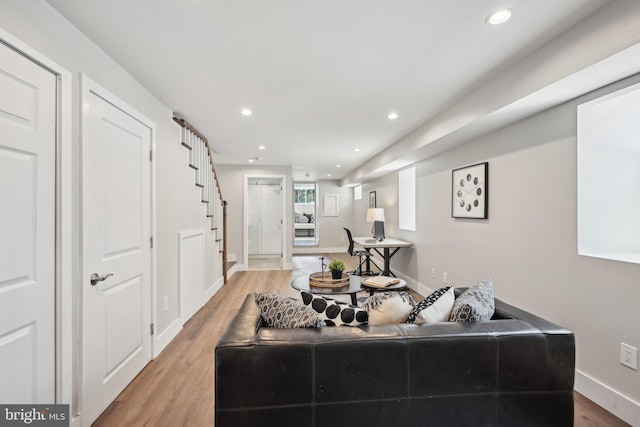 living room with light wood finished floors, stairway, and recessed lighting