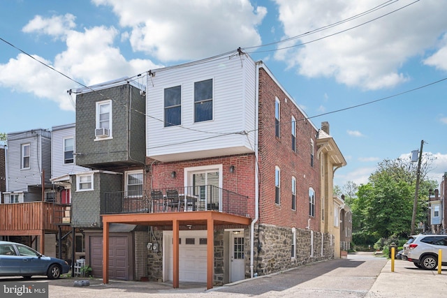 multi unit property featuring an attached garage, cooling unit, and stone siding