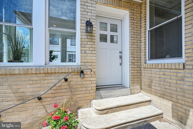 doorway to property with brick siding