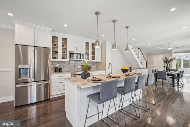 kitchen featuring backsplash, stainless steel appliances, white cabinetry, and dark wood-type flooring