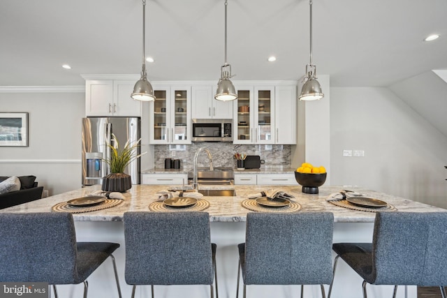 kitchen featuring recessed lighting, a kitchen bar, decorative backsplash, and appliances with stainless steel finishes