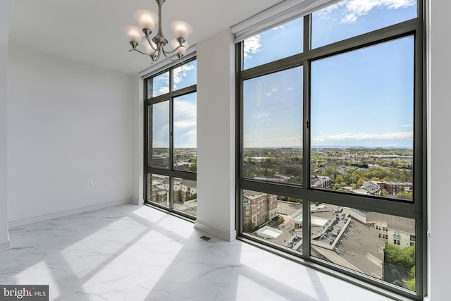interior space with marble finish floor, a wealth of natural light, and a chandelier