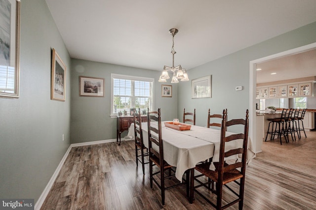dining space featuring baseboards, a notable chandelier, and dark wood-style floors