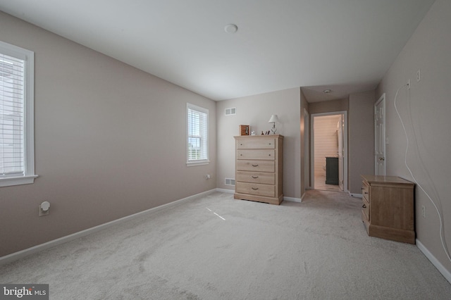 bedroom with baseboards, light carpet, and visible vents