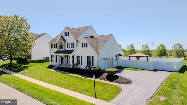 view of front of home with a garage, a front lawn, aphalt driveway, fence, and a shingled roof