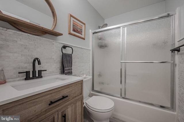full bathroom featuring backsplash, shower / bath combination with glass door, toilet, and vanity
