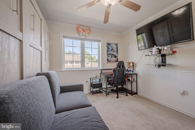 carpeted home office featuring crown molding, a wainscoted wall, and ceiling fan