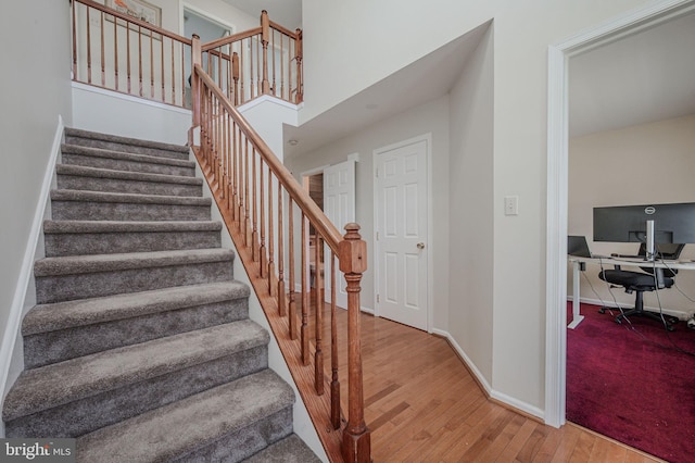 stairway with baseboards and wood finished floors