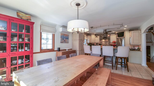 dining area with an AC wall unit, recessed lighting, arched walkways, light tile patterned floors, and decorative columns