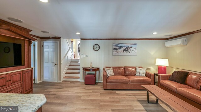living room with light wood finished floors, crown molding, stairs, and a wall mounted AC