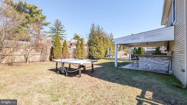 view of yard with outdoor dry bar, a patio area, and a fenced backyard
