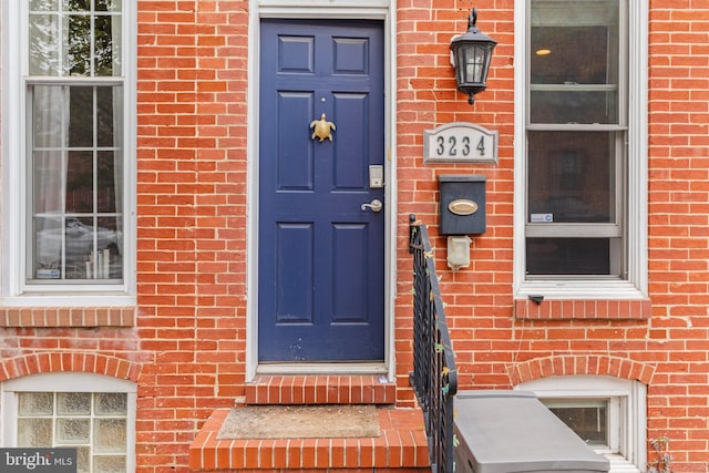 doorway to property with brick siding