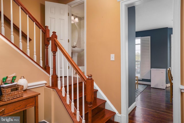 staircase featuring baseboards and wood finished floors