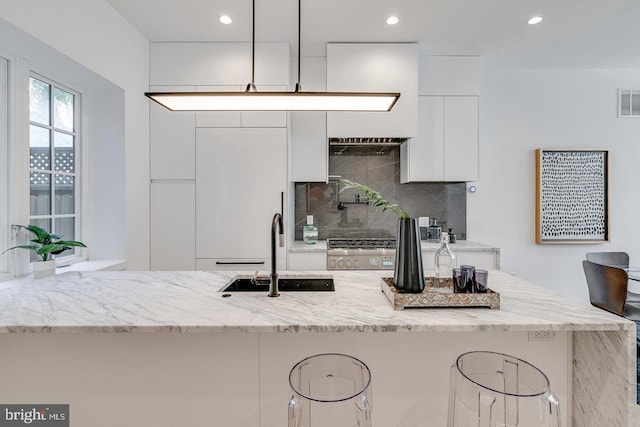 kitchen with decorative backsplash, white cabinets, modern cabinets, and a sink