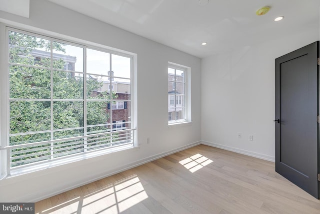 empty room with light wood-style flooring, recessed lighting, and a wealth of natural light