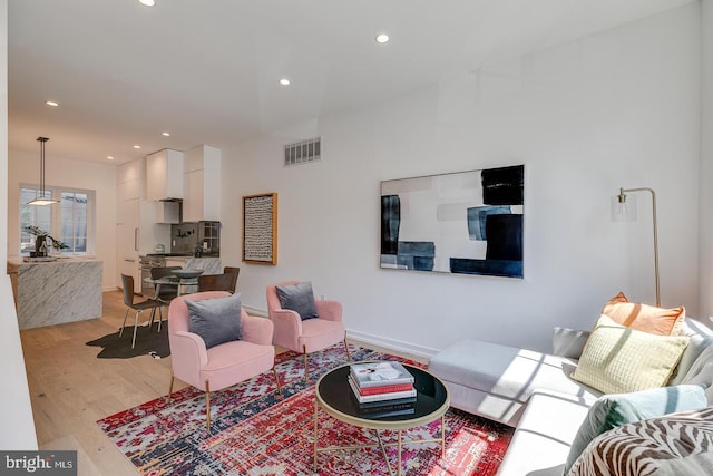 living room with recessed lighting, visible vents, and light wood-type flooring