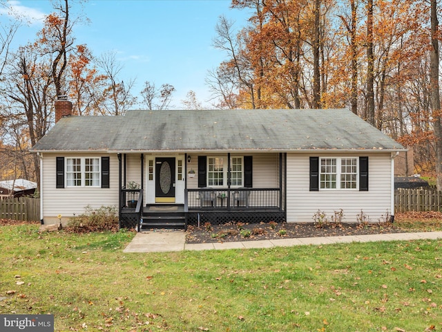 ranch-style house with fence, a chimney, a porch, and a front lawn