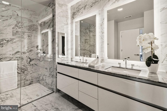 full bath with double vanity, marble finish floor, a sink, visible vents, and a marble finish shower