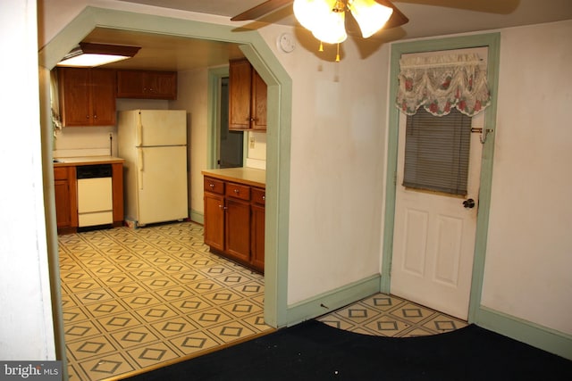 kitchen featuring light countertops, baseboards, light floors, white appliances, and a ceiling fan