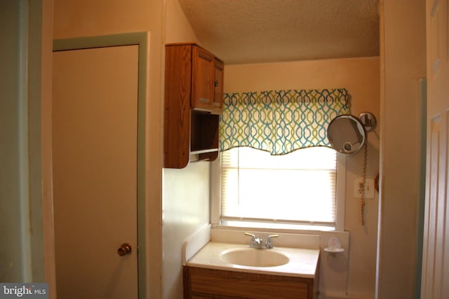 bathroom with a textured ceiling and vanity