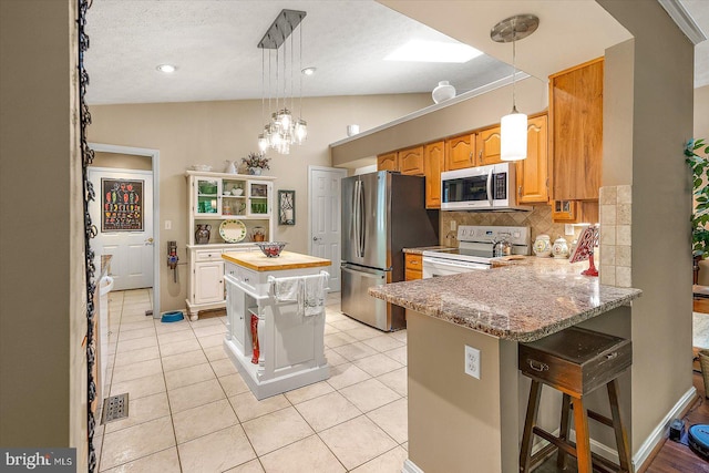 9 Edgewood Dr, Ocean Pines, MD 21811 - kitchen featuring decorative backsplash, a peninsula, light tile patterned flooring, and stainless steel appliances
