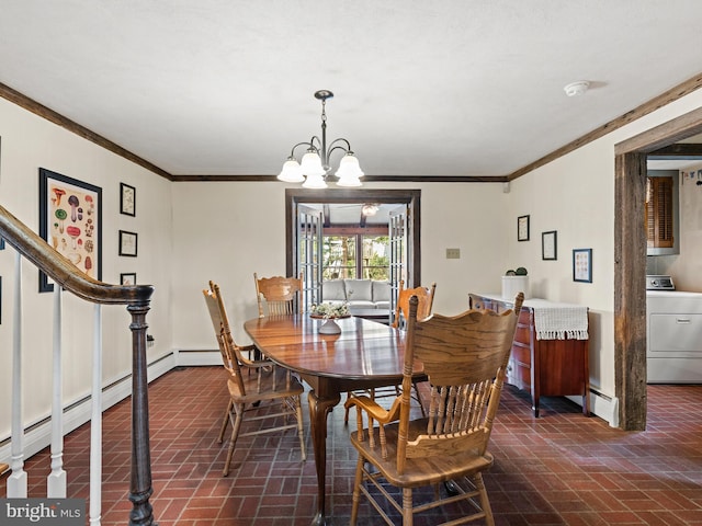 dining room with washer / clothes dryer, crown molding, brick floor, baseboard heating, and a chandelier