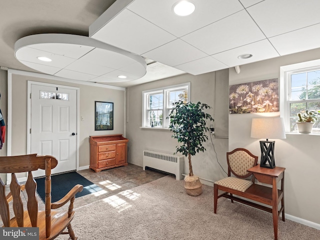 sitting room with baseboards, plenty of natural light, and radiator heating unit
