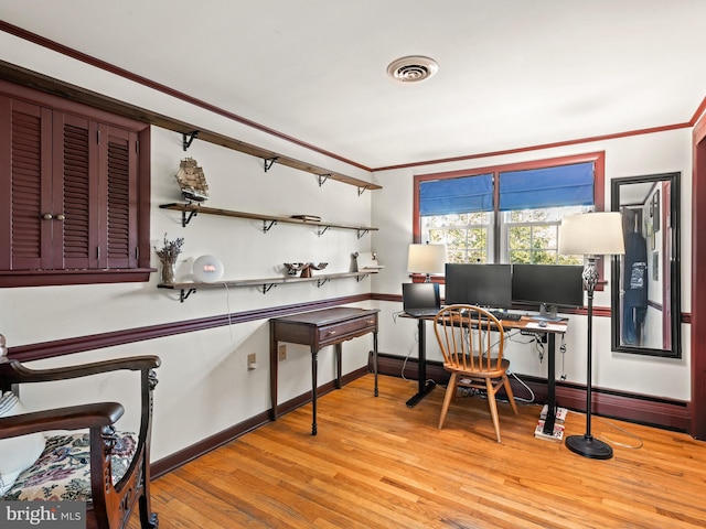 office area with visible vents, baseboards, ornamental molding, and light wood finished floors